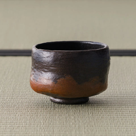 Kuro-raku black raku matcha bowl, three-quarter view of the waisted black bowl