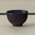 Plain reverse of the Black Weeping Sakura Chawan, showing its faceted body and throwing ridges on tatami