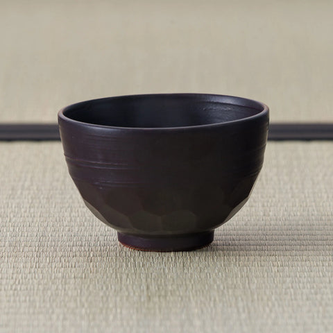 Plain reverse of the Black Weeping Sakura Chawan, showing its faceted body and throwing ridges on tatami