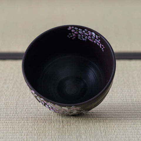Black Weeping Sakura Chawan tipped forward to reveal the dark interior, blossoms scattered just below the rim