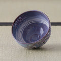 Purple Weeping Sakura Chawan tilted to show the brushed white spiral sweeping across the inside of the bowl