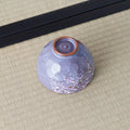 Purple Weeping Sakura Chawan upside down on tatami, revealing a spiralled foot and russet clay rim