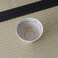Blue-and-white porcelain bowl viewed from above, interior ringed with blue lines.