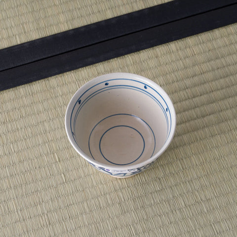 Blue-and-white porcelain bowl viewed from above, interior ringed with blue lines.