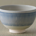 Pale blue and white striped tea bowl, side view on a tatami mat.