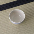 White bowl with a pale blue striped rim, viewed from above.
