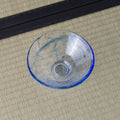 Pale blue glass tea bowl viewed from above, swirled blue interior.