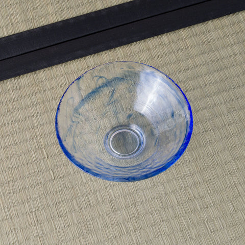 Pale blue glass tea bowl viewed from above, swirled blue interior.