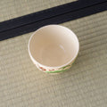 Cream bowl viewed from above at an angle, interior with painted decoration near the base.