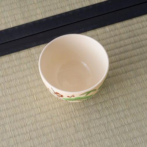 Cream bowl viewed from above at an angle, interior with painted decoration near the base.