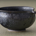 Close-up of the chawan's lustrous dark glaze and pouring lip