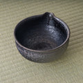 Overhead view into the dark matcha bowl showing the glazed interior