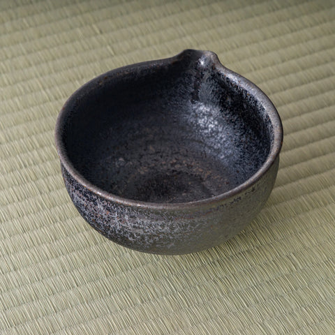 Overhead view into the dark matcha bowl showing the glazed interior