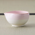 Pink-to-white glazed spouted bowl (katakuchi), side view on a tatami mat.