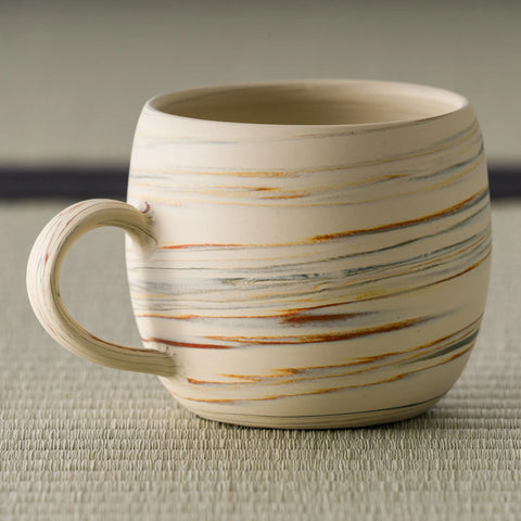 Close-up of the mug's horizontal brushed-slip stripes and handle
