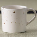 Close-up of the speckled glaze and handle of the pink mug