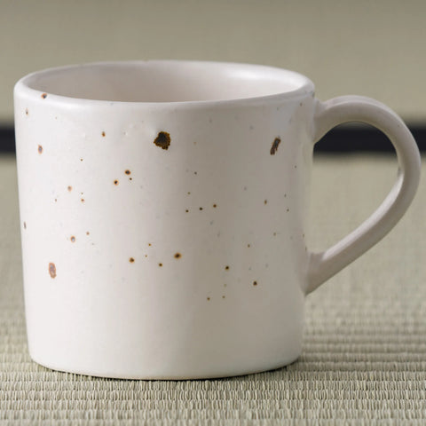 Close-up of the speckled glaze and handle of the pink mug