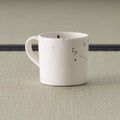 Speckled pink-cream mug seen from the front with the handle to the left