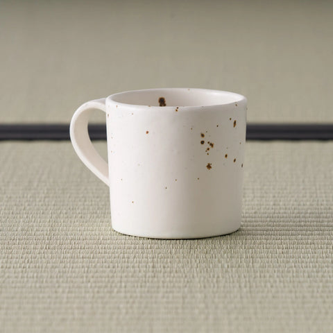 Speckled pink-cream mug seen from the front with the handle to the left