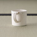 Side view of the speckled pink mug showing the curved loop handle