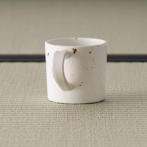 Side view of the speckled pink mug showing the curved loop handle