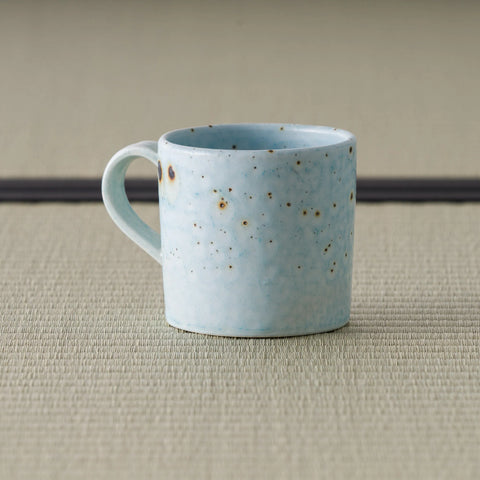Side view of the speckled blue-grey mug showing the curved loop handle