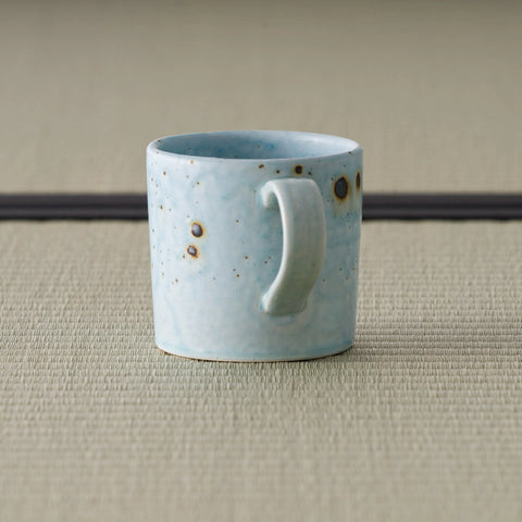 Speckled blue-grey mug seen from the front with the handle to the right