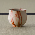 Front view of the cream yunomi with vivid orange-red hidasuki flame streaks