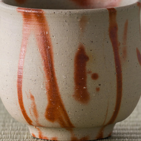 Close-up of the orange-red flame markings on the pale wood-fired yunomi