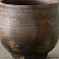 Close-up of the wood-fired yunomi surface showing its rough textured glaze and fire colors