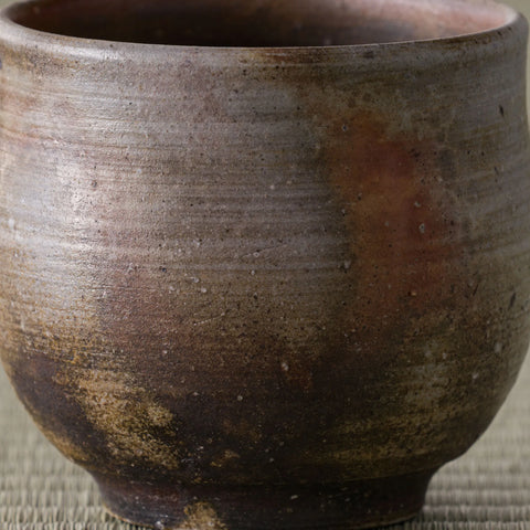 Close-up of the wood-fired yunomi surface showing its rough textured glaze and fire colors
