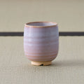 Pale pink-lavender glazed teacup, front view on a tatami mat.