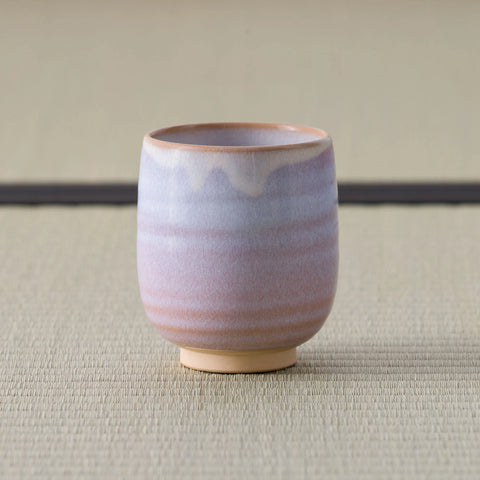 Pale pink-lavender glazed teacup, side view on a tatami mat.