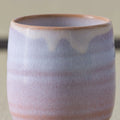 Pale pink-lavender glazed teacup, close side view on a tatami mat.