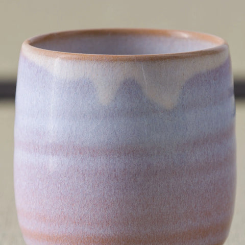 Pale pink-lavender glazed teacup, close side view on a tatami mat.