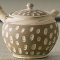 Close-up of the beige kyusu body showing the raised white polka-dot pattern and lid
