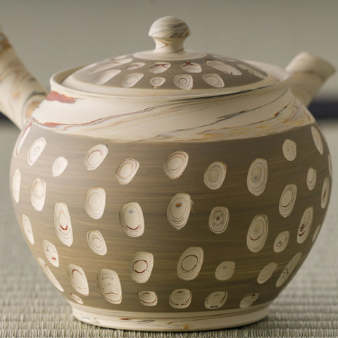 Close-up of the beige kyusu body showing the raised white polka-dot pattern and lid