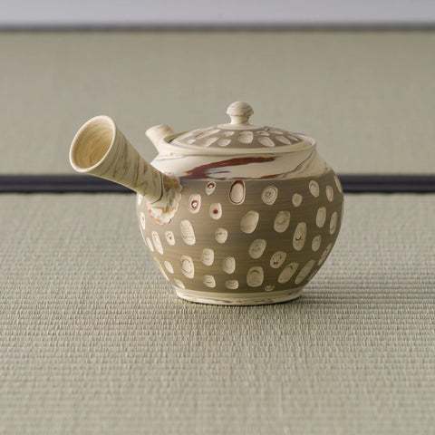 Beige stoneware kyusu with the spout angled forward, showing the white slip dots