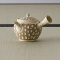 Rear three-quarter of the beige kyusu showing the side handle and dotted body
