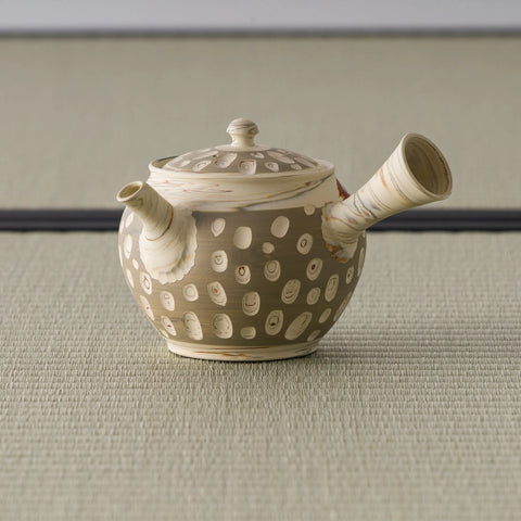 Rear three-quarter of the beige kyusu showing the side handle and dotted body