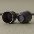 The two matching metallic-grey cups, one tipped to show the smooth interior