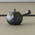 Bronze-grey unglazed kyusu teapot with an engraved band, three-quarter view with spout to the right