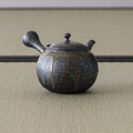 Carved metallic-grey kyusu with the spout angled to the left