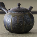 Three-quarter view highlighting the carved calligraphic band around the kyusu body