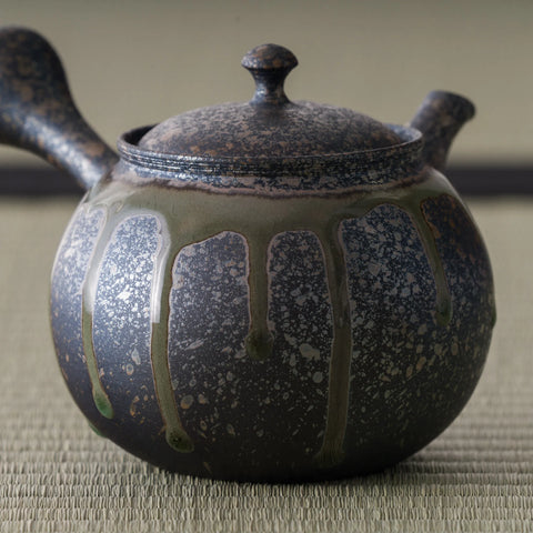 Three-quarter view highlighting the carved calligraphic band around the kyusu body