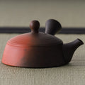 Lower-angle side view emphasizing the reddish shudei clay base of the kyusu