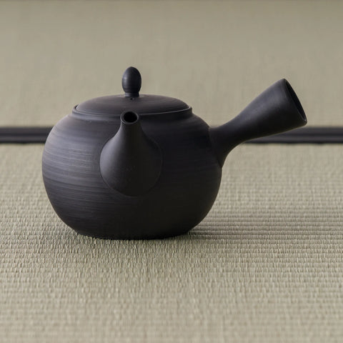 Dark kokudei clay side-handle kyusu teapot, three-quarter view with the spout to the right