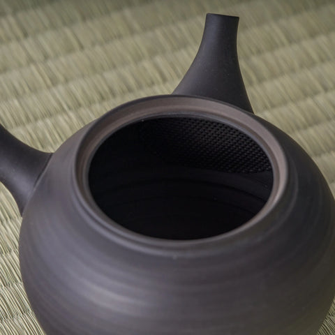High angle of the black kyusu showing the lid and the curve of the body