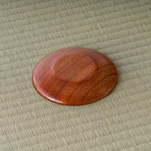 Low side angle of the round wooden chataku showing its raised rim and slim profile