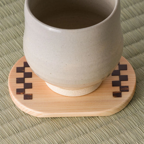 The light-wood chataku shown in use with a ceramic yunomi teacup resting on it